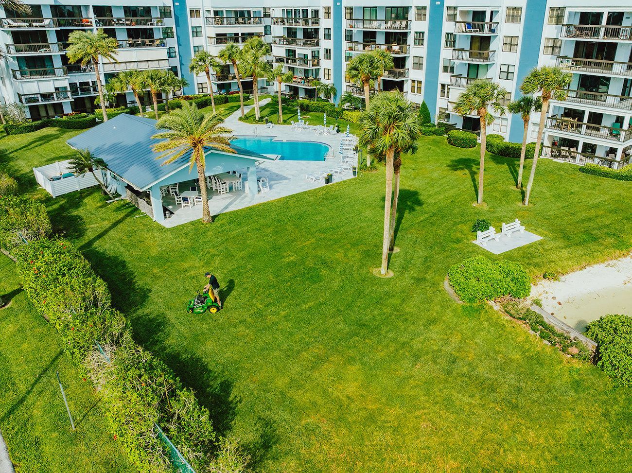Commercial lawn maintenance crew mowing large HOA community landscape for commercial landscaping services in Boynton Beach, FL