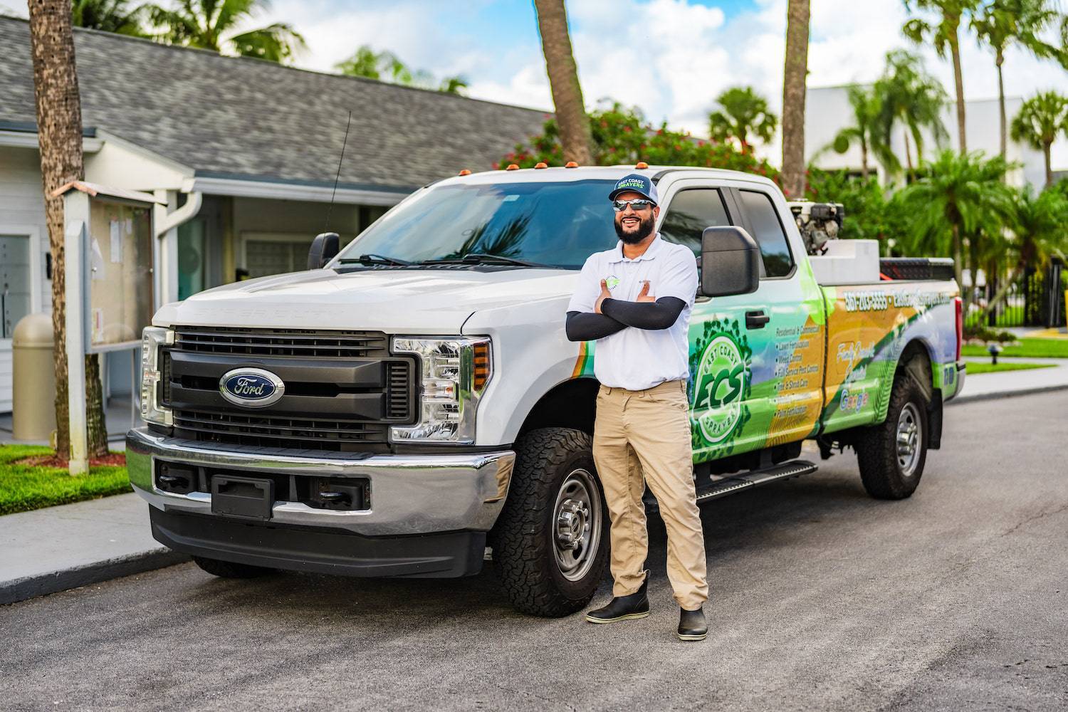 Landscape professional spraying lawn and shrubs at high-end community in Palm Beach County, FL