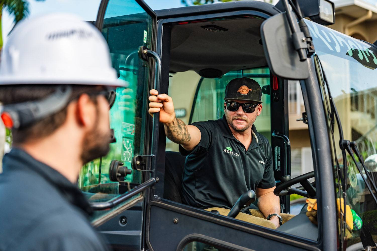 Landscaping supervisor speaking with crew member in work vehicle in Palm Beach Gardens FL
