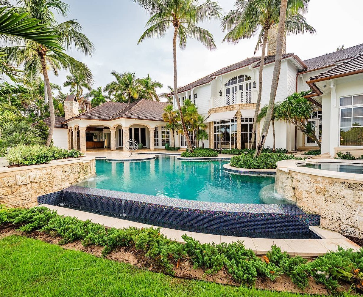 Luxury waterfront estate with resort-style pool and tropical landscaping in Palm Beach County