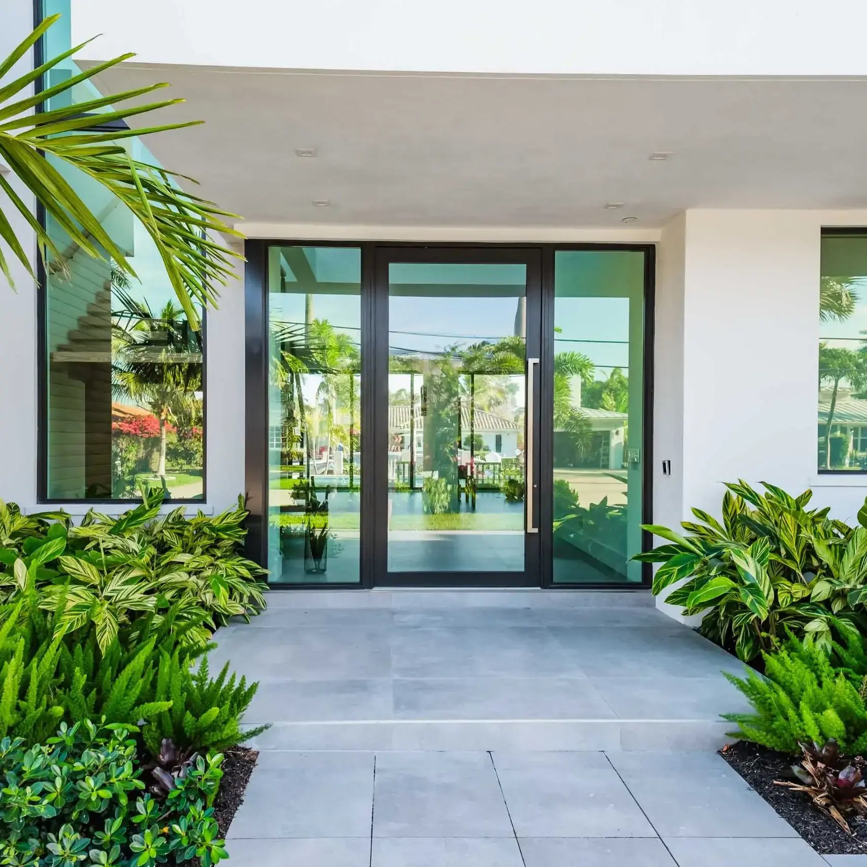 Modern luxury home entrance with tropical landscape design and professional landscape services in Palm Beach, FL