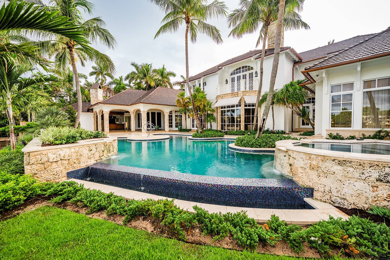 Waterfront pool and spa with integrated drainage and planting beds in Manalapan, FL
