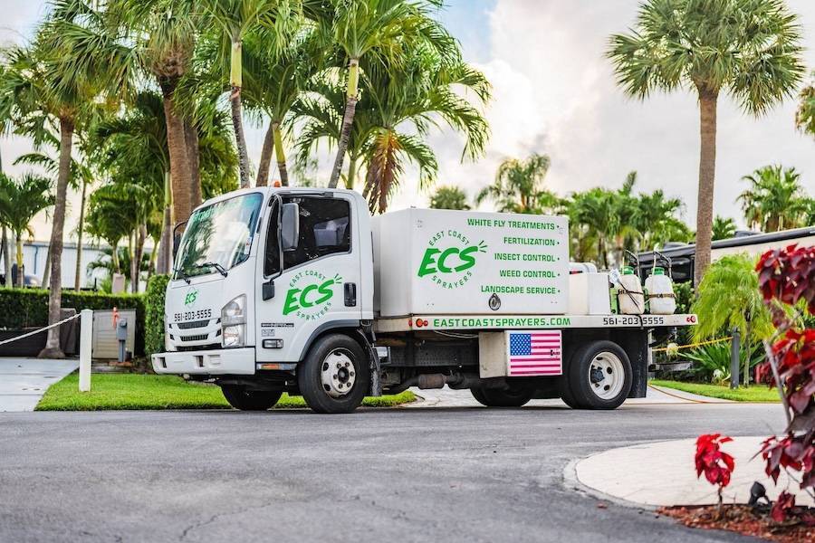 Commercial lawn maintenance near me service spraying turf and planting beds in Boca Raton, FL-1