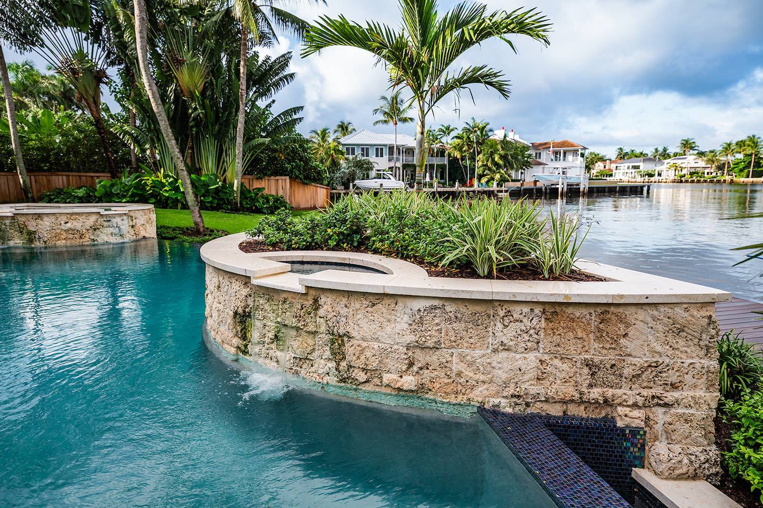 Luxury backyard with pool, palm trees, and landscape company installation in Delray Beach, FL