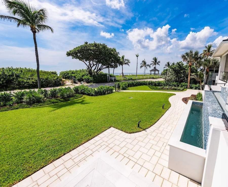 Luxury coastal estate landscape with manicured lawn and paver patio in Palm Beach FL-2