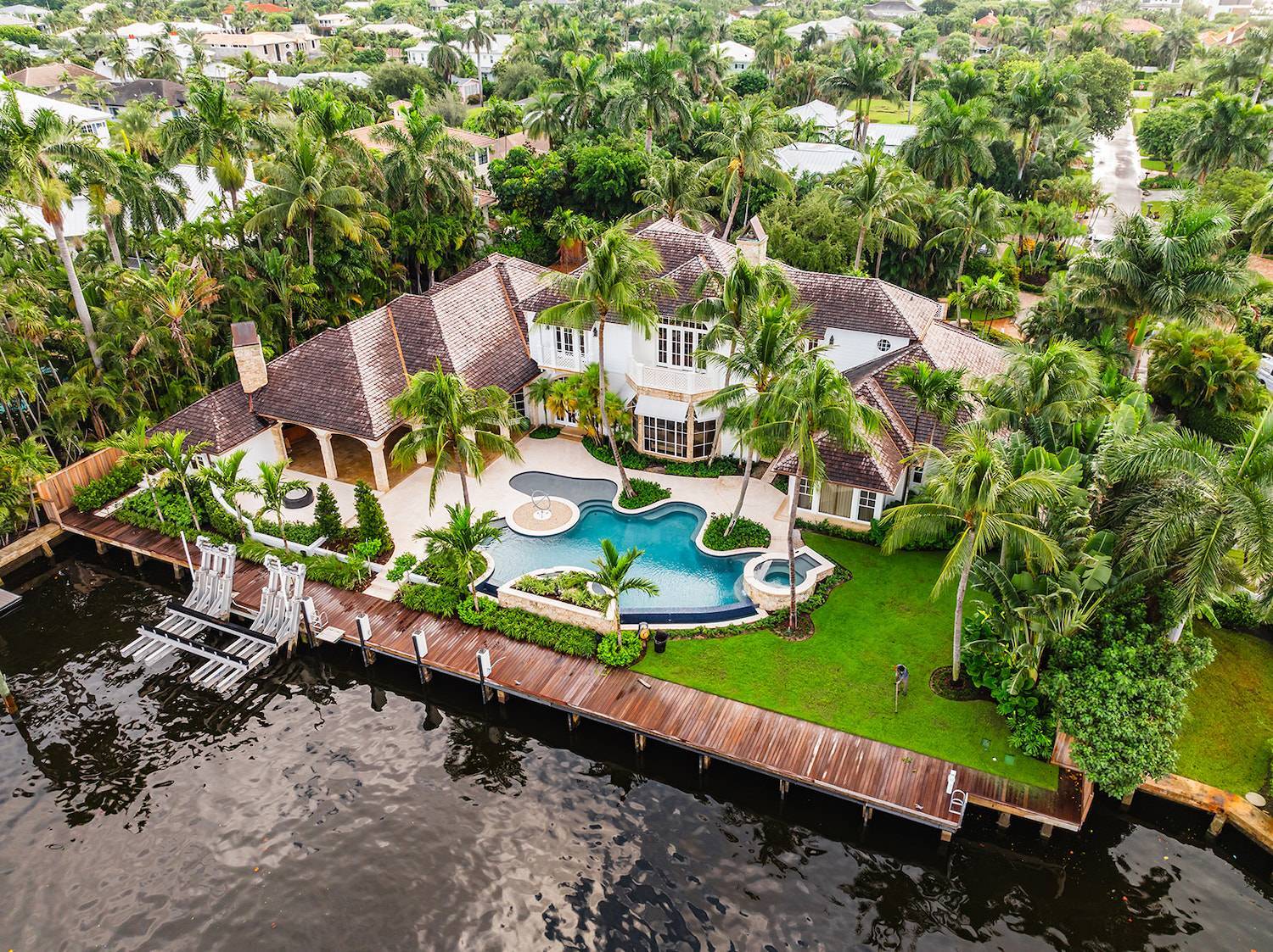 Luxury waterfront backyard with custom pool design and landscape services in Boca Raton, FL