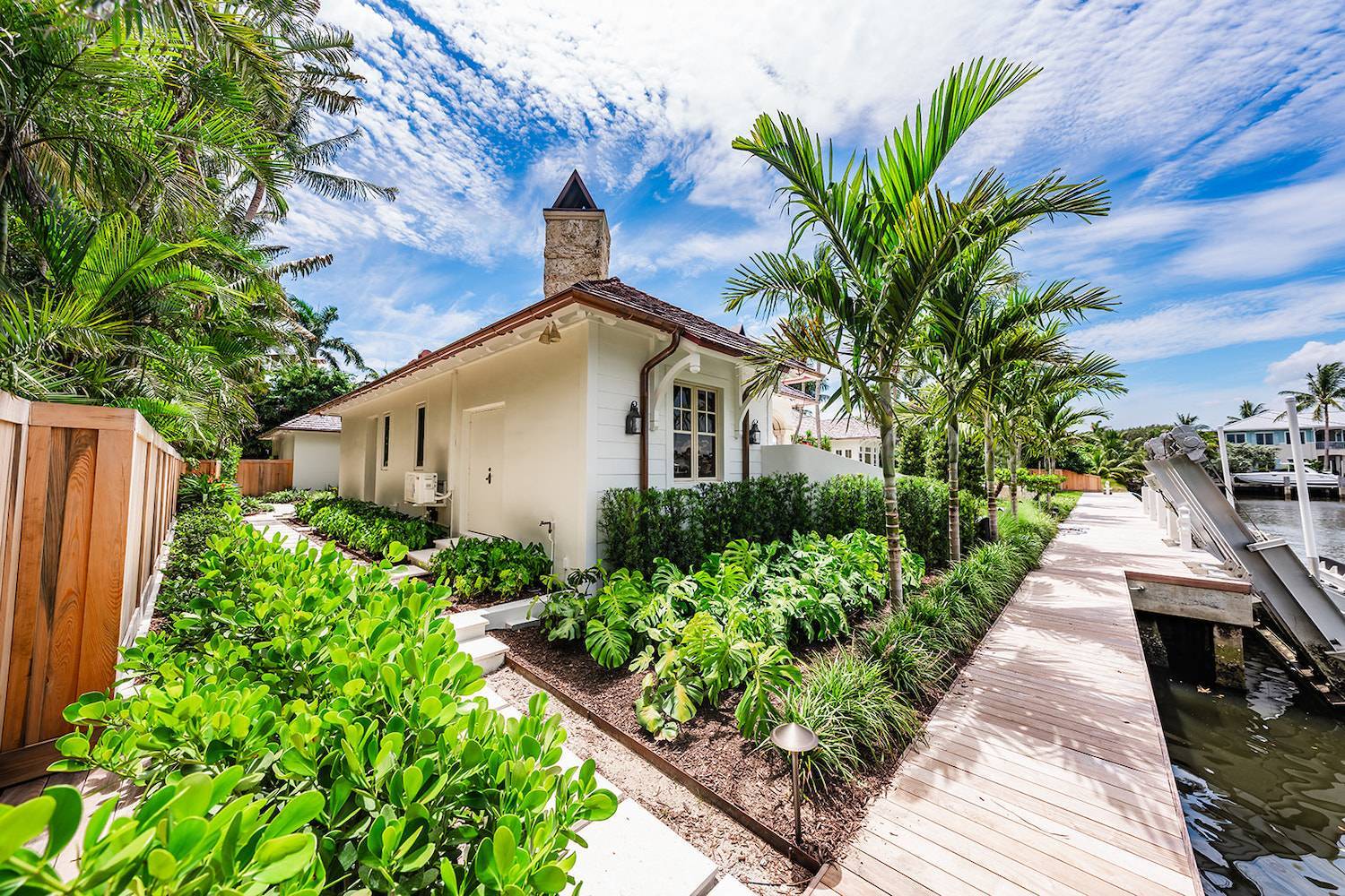 Waterfront estate landscaping with tropical plantings and dockside garden beds in Palm Beach County