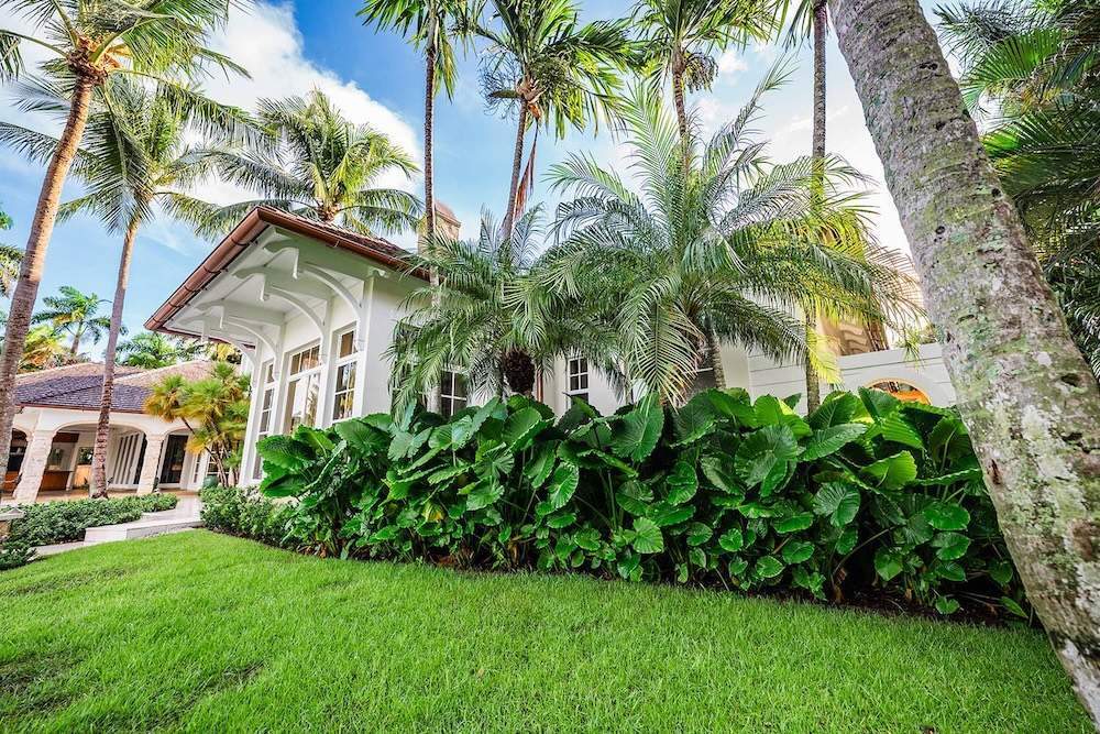 Waterfront estate with palm trees, pool, and professional landscape company work in Manalapan, FL-1